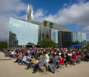 In this 2013 file photo, people pray for immigration reform against the backdrop of Christ Cathedral in Garden Grove, Calif., in the Diocese of Orange. People all over the world are being invited to "digitally dedicate" one of the cathedral's 11,236 glass window panes. (CNS photo/Tim Rue) See ORANGE-CATHEDRAL-GLASS Nov. 22, 2016.