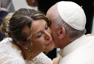 A newly married woman wearing her wedding dress kisses Pope Francis during his general audience in Paul VI hall at the Vatican Nov. 30. (CNS photo/Paul Haring) See POPE-AUDIENCE-DEPARTED Nov. 30, 2016.