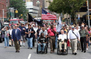 Detective Steven McDonald of the New York Police Department, in wheelchair at right, participates in the 10th annual Father Mychal F. Judge Walk of Remembrance in New York in Sept. 2011. McDonald, who founded the walk in 2002, died Jan. 10 at a Long Island hospital at age 59. (CNS photo/Gregory A. Shemitz) See OBIT-MCDONALD Jan. 11, 2017.