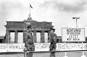 Border policemen stand next to the sign at the Berlin Wall and Brandenburg Gate in Berlin June 17, 1986. The sign says: "Achtung! Sie verlassen jetzt West-Berlin" (Attention, you are leaving West Berlin). The prayer intentions written by Germans for the 2017 Week of Prayer for Christian Unity call to mind the Berlin Wall. (CNS photo/Wolfgang Kumm, EPA) See VATICAN-LETTER-UNITY-WEEK Jan. 12, 2017.