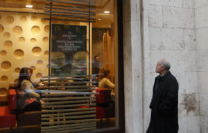 A priest looks in the window of the newly opened McDonald's near the Vatican Jan. 12. The McDonald's will collaborate with Italian aid organization, "Medicinia Solidale," and the papal almoner's office to help feed the poor and homeless around the Vatican. (CNS photo/Paul Haring) See VATICAN-MCDONALDS Jan. 12, 2017.