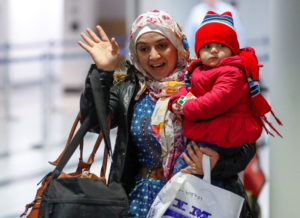 Syrian refugee Baraa Haj Khalaf and her daughter, 1-year-old Shams, wave after arriving Feb. 7 at O'Hare International Airport in Chicago. (CNS photo/Kamil Krzaczynski, Reuters) See REFUGEES-VASQUEZ-APPEAL Feb. 10, 2017.