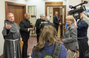 Bishop Gregory J. Hartmayer of Savannah, Ga., Atlanta Archbishop Wilton D. Gregory and Bishop Felipe j. Estevez of St. Augustine, Fla., speak to the media Jan. 31 before meeting with acting District Attorney Hank Syms (holding the door open) to discuss details of the case against Steven Murray. Murray is accused of murdering Father Rene Robert of the Diocese of St. Augustine last April. (CNS photo/St. Augustine Catholic, Woody Huband) See BISHOPS-MERCY-MURRAY Feb. 1, 2017.