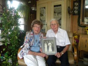 Bill and Evelyn Schulte of Dodge, Neb., seen in a 2016 photo, hold a portrait of themselves taken on their wedding day in 1946. The couple, who are members of St. Wenceslaus Parish in Dodge, will celebrate their 71st wedding anniversary Feb. 12. (CNS photo/Kathy Kauffold, Dodge Criterion) See MARRIAGE-LONGTIME-COUPLES Feb. 9, 2017.