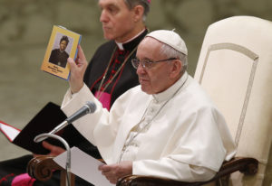 Pope Francis holds a booklet with an image of Sudanese St. Josephine Margaret Bakhita during his general audience in Paul VI hall at the Vatican Feb. 8. Marking the feast of St. Bakhita, a former slave, the pope urged Christians to help victims of trafficking and migrants. (CNS photo/Paul Haring) See POPE-AUDIENCE-TRAFFICKING Feb. 8, 2017.