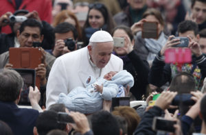 Pope Francis greets a baby during his general audience in St. Peter's Square at the Vatican Feb. 22. (CNS photo/Paul Haring) See POPE-AUDIENCE-CREATION Feb. 22, 2017.