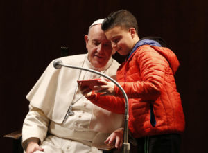 A boy takes a selfie with Pope Francis as the pope meets children before celebrating Mass at St. Mary Josefa Parish in Rome Feb. 19. (CNS photo/Paul Haring) See POPE-PARISH-MASS Feb. 19, 2017.