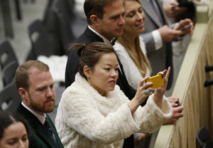 Newlywed Kelly Michelle Byrne of Hong Kong, accompanied by her husband, Geaspar, left, takes a photo during Pope Francis' general audience in Paul VI hall at the Vatican Feb. 8. Each week dozens of newlyweds from around the world meet the pope and receive a special papal blessing at the general audience. (CNS photo/Paul Haring) See VATICAN-LETTER-NEWLYWEDS Feb. 9, 2017.