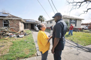 Father Geoffrey Omondi Muga, right, a member of the Franciscan Missionaries of Hope, who is pastor of Resurrection of Our Lord Parish in New Orleans East, consoles parishioner Carolm Adams. Her brick home was heavily damaged by a tornado Feb. 7. (CNS photo/Peter Finney Jr., Clarion Herald) See TORNADO-VICTIMS-FAITH Feb. 8, 2017.