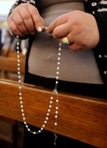 An Iraqi woman holds a rosary during Mass in 2016 at a church in Baghdad. A year after the U.S. genocide declaration, the Knights of Columbus is continuing its humanitarian support for persecuted Christian communities in the region by contributing nearly $2 million in new assistance. (CNS photo/Ali Abbas, EPA) See KNIGHTS-PRAYERS-PERSECUTED March 15, 2017.