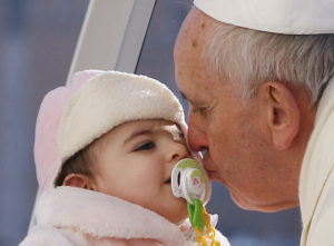 Pope Francis kisses a baby during a general audience in St. Peter's Square Dec. 18, 2013. March 13 marked the fourth anniversary of the Argentine cardinal's election as pope. (CNS photo/Paul Haring)