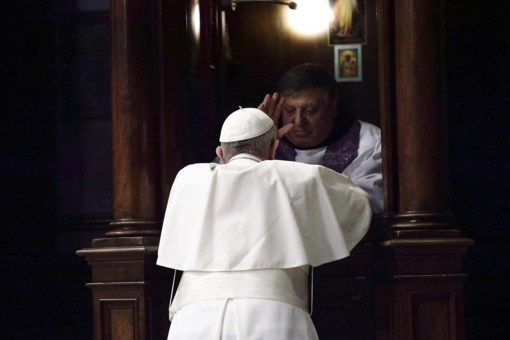 Pope Francis kneels before a priest to confess during a Lenten prayer ...