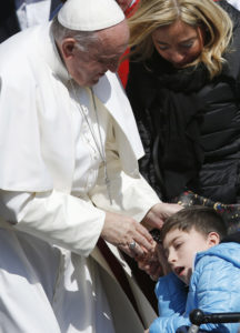 Pope Francis greets a boy while meeting the disabled during his general audience in St. Peter's Square at the Vatican March 15. (CNS photo/Paul Haring) See POPE-AUDIENCE-DIGNITY March 15, 2017.