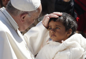 Pope Francis greets a child during his general audience in St. Peter's Square at the Vatican March 29. (CNS photo/Paul Haring) See POPE-AUDIENCE-SALVATION March 29, 2017.