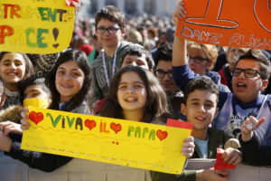Young people hold signs as they attend Pope Francis' general audience in St. Peter's Square at the Vatican March 29. (CNS photo/Paul Haring) See POPE-AUDIENCE-SALVATION March 29, 2017.