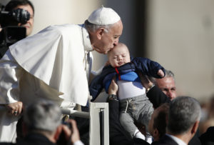 Pope Francis kisses a baby during his general audience in St. Peter's Square at the Vatican March 29. (CNS photo/Paul Haring) See POPE-AUDIENCE-SALVATION March 29, 2017.