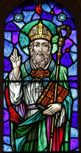 St. Patrick is depicted in a stained-glass window at St. Aloysius Church in Great Neck, N.Y. Archbishop Eamon Martin of Armagh, Northern Ireland, said that "as Irish people, we cannot think of St. Patrick without acknowledging the enormous humanitarian and pastoral challenges facing growing numbers of people who find themselves displaced and without status in our world." (CNS photo/Gregory A. Shemitz) See MARTIN-SAINT-PATRICK-SLAVE March 16, 2017.