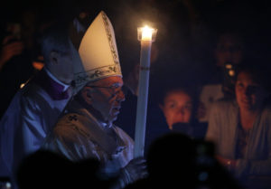 Pope Francis carries a candle as he arrives to celebrate the Easter Vigil in St. Peter's Basilica at the Vatican April 15. (CNS photo/Paul Haring) See POPE-EASTER-ROUNDUP April 16, 2017.