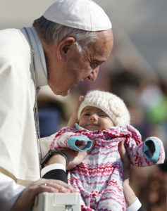 Pope Francis greets a baby during his general audience in St. Peter's Square at the Vatican April 12. (CNS photo/Paul Haring) See POPE-AUDIENCE-SEED April 12, 2017.
