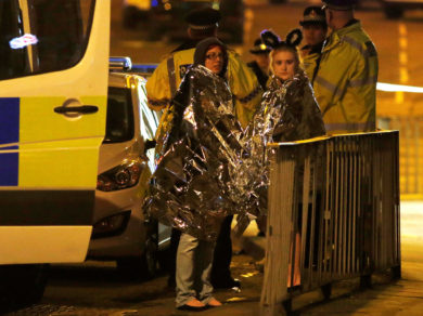 Two women wrapped in thermal blankets stand near Manchester Arena in England where U.S. singer Ariana Grande had been performing May 22. At least 22 people, including children, were killed and dozens wounded after an explosion at the concert venue. Authorities said it was Britain's deadliest case of terrorism since 2005. (CNS photo/Jon Super, Reuters) See MANCHESTER-ARENA-REACT May 23, 2017.