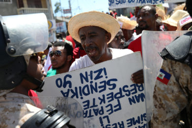 A man argues with a Haitian National Police officer March 1  as a police line blocks a street during a march calling for better labor conditions in Port-au-Prince. Haitians in the U.S. since a devastating 2010 earthquake are urging the U.S. Department of Homeland Security to renew their Temporary Protected Status designation because conditions have not appreciably improved in their homeland. (CNS photo/Andres Martinez Casares, Reuters) See HAITIANS-PROTECTED-STATUS May 11, 2017
