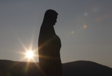 The sun sets behind a statue of Mary on Apparition Hill in Medjugorje, Bosnia-Herzegovina, in this 2011 file photo. (CNS photo/Paul Haring) See MEDJUGORJE-REPORT May 17, 2017