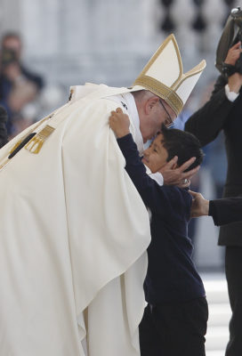 Pope Francis embraces Lucas Batista from Brazil as offertory gifts are presented during the canonization Mass of Sts. Francisco and Jacinta Marto, two of the three Fatima seers, at the Shrine of Our Lady of Fatima in Portugal, May 13. The Mass marked the 100th anniversary of the Fatima Marian apparitions, which began on May 13, 1917. (CNS photo/Paul Haring) See POPE-FATIMA-CANONIZATION May 13, 2017.