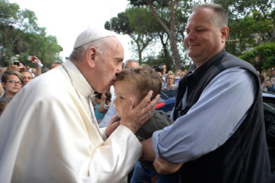 Pope Francis kisses a child during a visit to give an Easter blessing to homes in a public housing complex in Ostia, a Rome suburb on the Mediterranean Sea, May 19. Continuing his Mercy Friday visits, the pope blessed a dozen homes in Ostia. (CNS photo/L'Osservatore Romano) See POPE-MERCY-FRIDAY-BLESSING May 19, 2017.