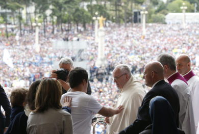 A man reaches to touch Pope Francis after the pope blessed the sick with the Eucharist at the conclusion of the canonization Mass of Sts. Francisco and Jacinta Marto, two of the three Fatima seers, at the Shrine of Our Lady of Fatima in Portugal May 13. The Mass marked the 100th anniversary of the Fatima Marian apparitions, which began on May 13, 1917. (CNS photo/Paul Haring) See POPE-FATIMA-CANONIZATION May 13, 2017.