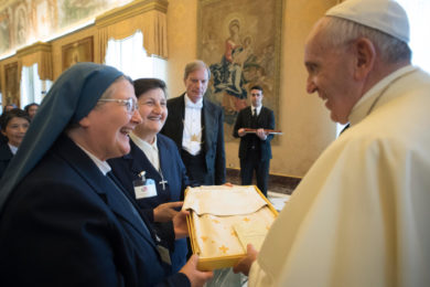Pope Francis accepts a gift as he greets participants in the general chapter of the Sister Disciples of the Divine Master during an audience at the Vatican May 22. (CNS photo/L'Osservatore Romano) See POPE-NUNS-JOY May 22, 2017.