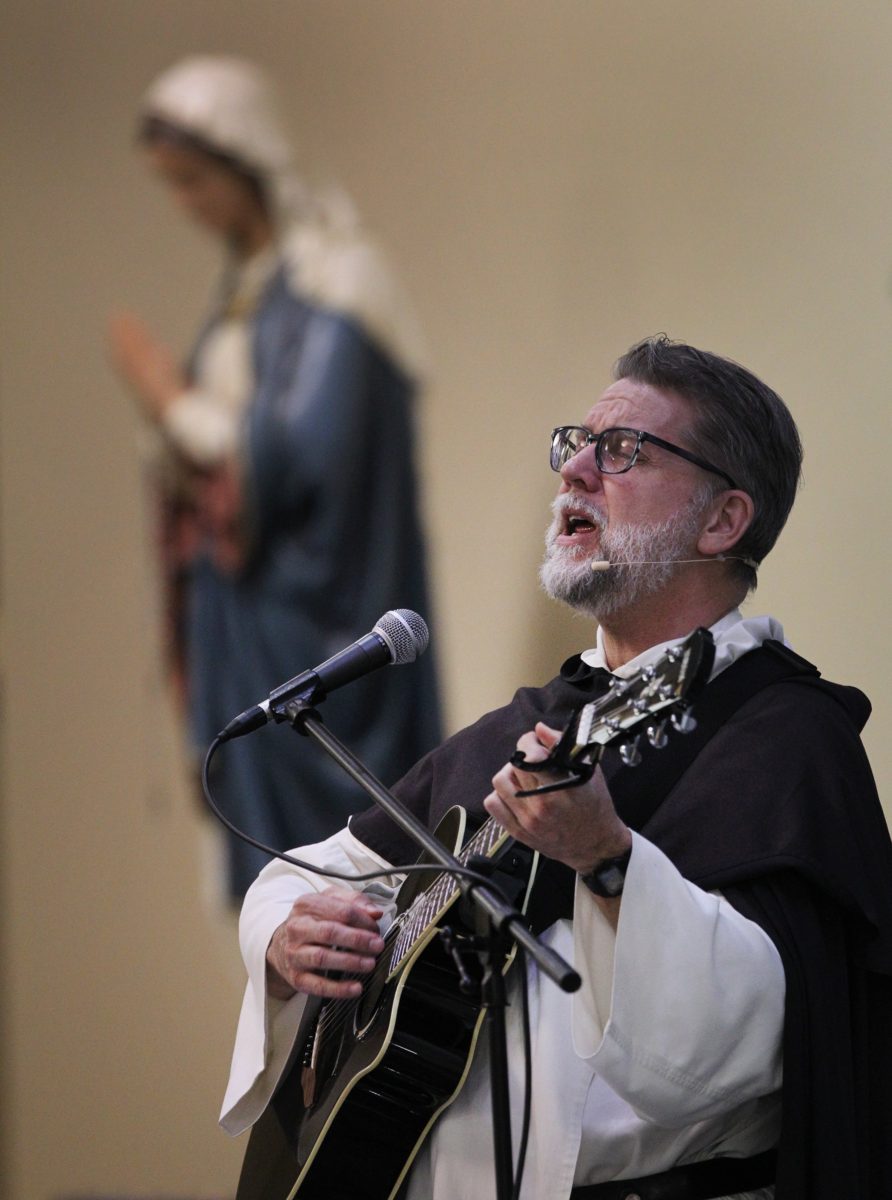 Dominican Father Bill Garrott sings as he leads a parish mission at ...