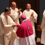 Msgr Christopher Connelly is congratulated by Springfield Bishop Mitchell Rozanski during a Mass at St. Michael's Cathedral.