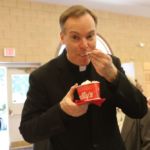 Msgr. Christopher Connelly, diocesan vicar general and rector of St. Michael's Cathedral, enjoys an ice cream treat at the celebration of his 25th anniversary of ordination. The reception was held at the Bishop Marshall Center adjacent to the cathedral.