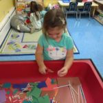 A preschool student works at the sensory table at St. Thomas the Apostle School in West Springfield.