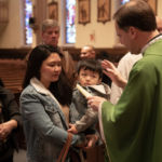 Msgr. Christopher Connelly, rector of St. Michael's Cathedral, offers the Blessing of Throats to parishioners during the celebration of the feast of St. Blaise.