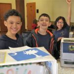 Students London Stinson, Atticus VanOostveen and Vianka Cornejo enjoy the State Box Exhibit Day at St. Joan of Arc School in Chicopee.