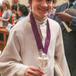 A young member of the Cathedral Choir of Boys and Adults displays the chocolate cross he received from Bishop Mitchell Rozanski after the Easter Mass at St. Michael's Cathedral. The tradition of giving chocolate to children at the Easter Masses is believed to have been started by the late Bishop Joseph Maguire.