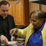 Msgr. Christopher Connelly, rector of St. Michael's Cathedral, helps serve guests at the Lenten Luncheon hosted by the Ladies of St. Peter Claver.