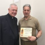 Stigmatine Father Robert White, pastor of Our Lady of Mt. Carmel Parish, Springfield, acknowledges Michael Napoli, who has been an altar server every week at St. Anthony devotions for the last 50 years.